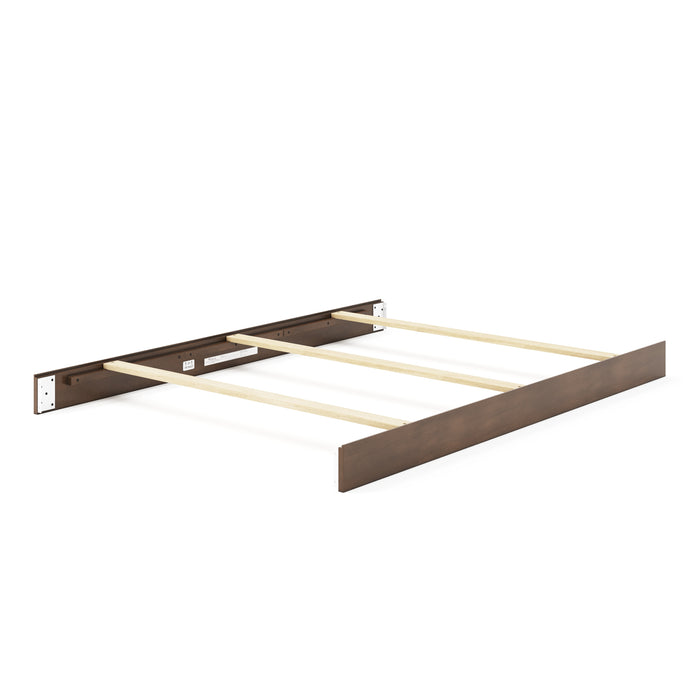 A partially assembled Child Craft F06401 full-size bed shows a dark brown headboard and footboard, with cocoa bean-finished bed rails and light pine support slats running across the width.