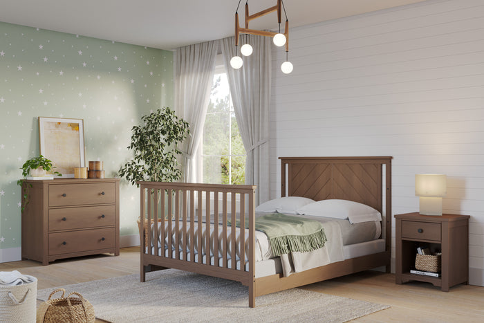 A cozy bedroom with a Child Craft F06401 full-size bed featuring Dusty Heather bed rails, matching dresser and nightstand, green star-patterned accent wall, white shiplap wall, potted plant, large window with sheer curtains, and a modern pendant light.