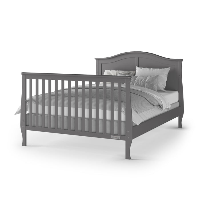 The Child Craft F06454 Full-Size Bed Rails in Cool Gray feature a slatted footboard and curved headboard. Displayed with white bedding and gray blankets, the bed appears on a plain white background. Compatible with select crib conversion kits.