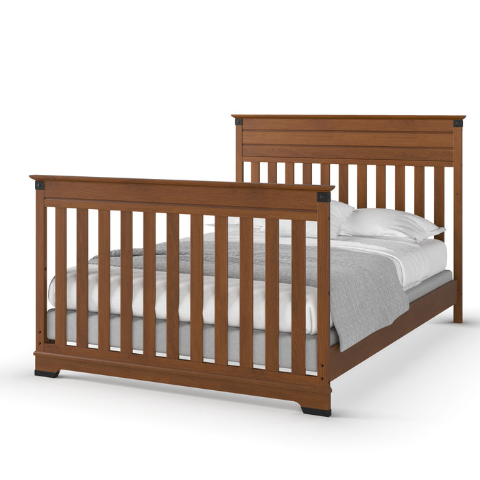 The Child Craft F06474 Full-Size Bed Rails in Coach Cherry feature a wooden frame with vertical slats on the headboard and footboard, shown with a made-up bed, white pillows, sheets, and a light gray blanket.