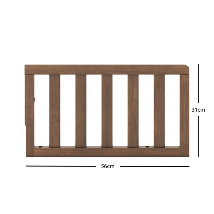 The Child Craft F09501 - Toddler Guard Rail in Cocoa Bean features a wooden panel with vertical slats, measuring 56 cm wide by 31 cm tall, shown against a white background with labeled measurements. Perfect for crib conversion.