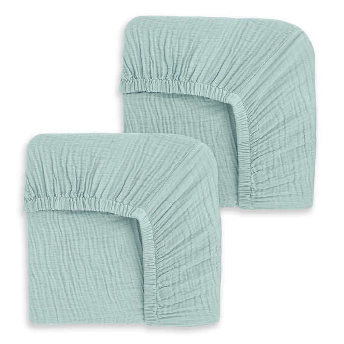 The HALO Fitted Crib Sheets 100% Organic Cotton Muslin 2 Pack features two neatly folded light teal sheets with elastic edges and soft, breathable fabric—offering comfort and style for your nursery.