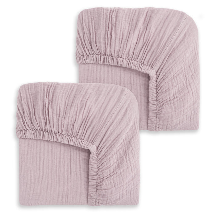 Two mauve-colored HALO Fitted Crib Sheets, 100% Organic Cotton Muslin (2 Pack), are folded with elastic edges visible on a white background. The soft, textured fabric suggests comfort and a gently crinkled appearance.