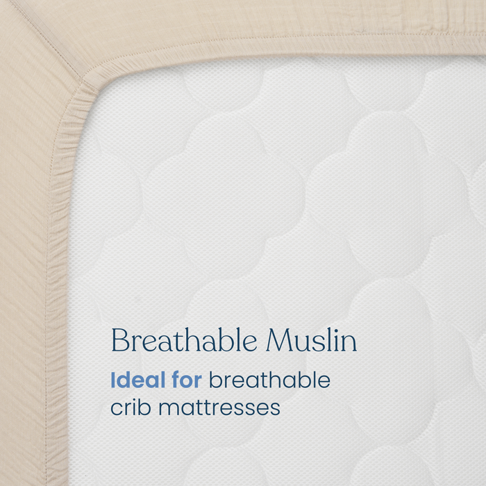 Close-up of HALO Fitted Crib Sheets 100% Organic Cotton Muslin 2 Pack in beige. Text on the sheet reads: “Breathable Muslin. Ideal for breathable crib mattresses.” Fabric texture and mattress surface are clearly visible.
