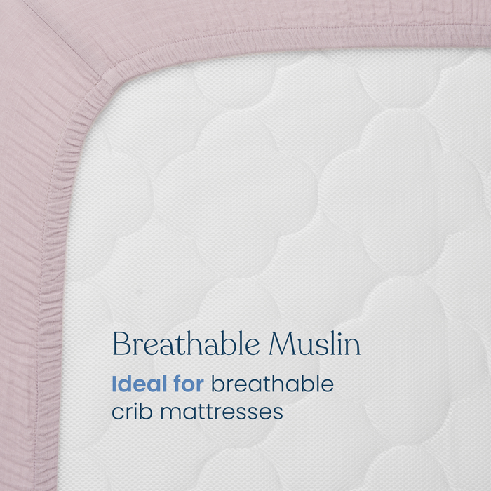 Close-up of the HALO Fitted Crib Sheets 100% Organic Cotton Muslin 2 Pack in mauve on a white crib mattress. Text on the mattress reads: “Breathable Muslin. Ideal for breathable crib mattresses.”.