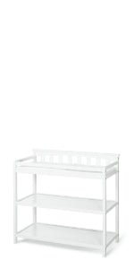 The Child Craft Flat Top Baby Changing Table in matte white features baby-safe finishes, two open storage shelves, and raised sides for safety, all showcased against a plain white background.