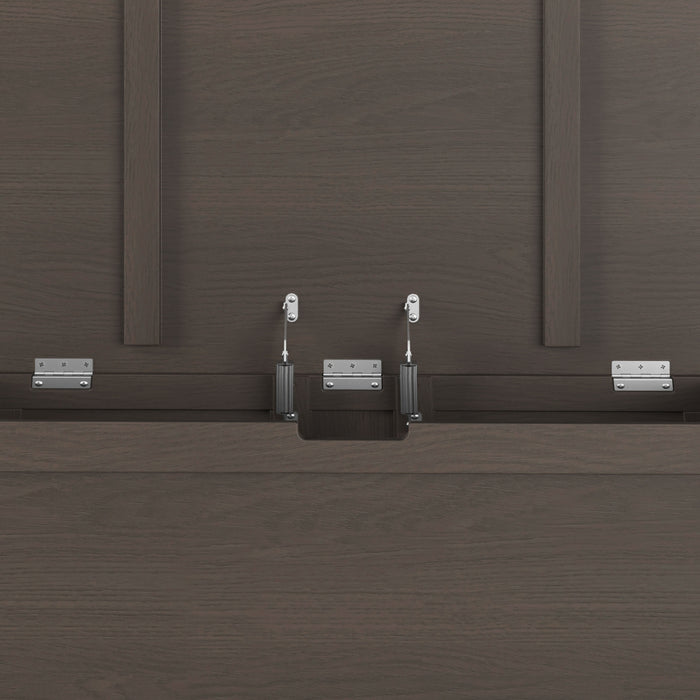 Close-up of the Child Craft Harmony 33" Kids Toy Box in Dapper Gray, showing its dark wood panels and metal brackets and hinges used for assembly. Vertical and horizontal wood panels feature in the background.