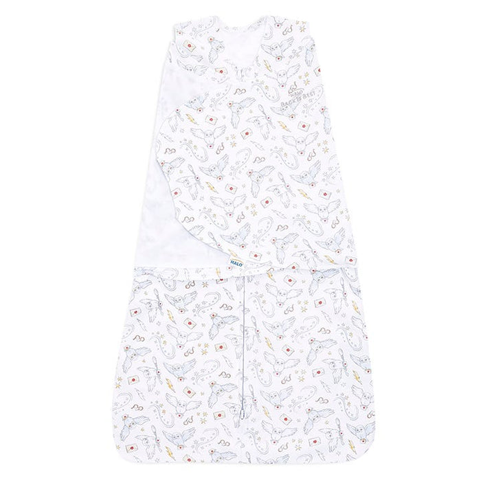The Harry Potter™ Swaddle 100% Cotton TOG 1.5 from HALO features a whimsical animal and shape pattern, with gray dinosaurs accented in orange and red. Designed for healthy hip development, it has a front zipper and adjustable Velcro swaddle fasteners for a snug, comfortable fit.