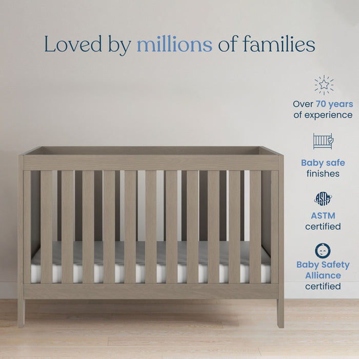 A Child Craft Kieran 3-in-1 Convertible Crib in Crescent Gray sits under a "Loved by millions of families" sign. To the right, icons note 70+ years of expertise, baby-safe finishes, and ASTM and Baby Safety Alliance certifications.