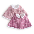 Two aden + anais organic cotton muslin burpy bibs feature a light pink version with a subtle flower pattern and a darker pink one with scattered small flowers, both crafted from GOTS certified organic cotton and displayed overlapping on a crisp white background for style and sustainability.