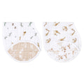 The aden + anais organic cotton muslin burpy bibs 2 pack includes two GOTS certified burp cloths. Both white with animal prints: green/brown dinosaurs on one, and brown giraffes/zebras on the other. They feature curved beige undersides with a white leaf design.