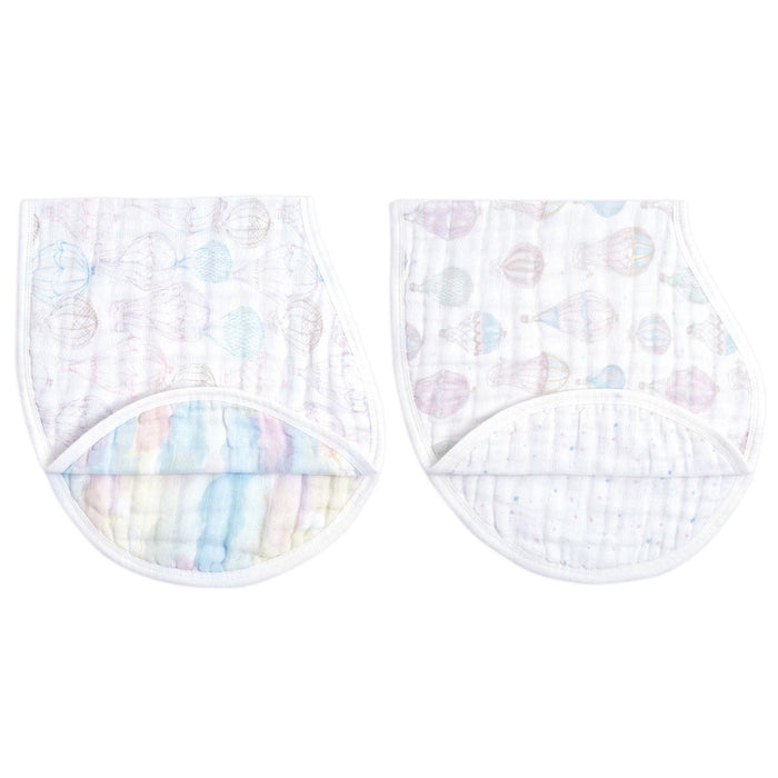 The aden + anais organic cotton muslin burpy bibs 2 pack includes two GOTS certified quilted white cloths featuring pastel hot air balloons and soft rainbow stripes. These curved designs with an overlapping flap offer ultimate comfort and style for babies.