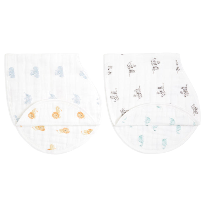 The aden + anais organic cotton muslin burpy bibs 2 pack includes two GOTS certified white cloths: one with a blue cloud pattern and the other with grey and beige elephants, both designed with a curved shape for shoulder draping.