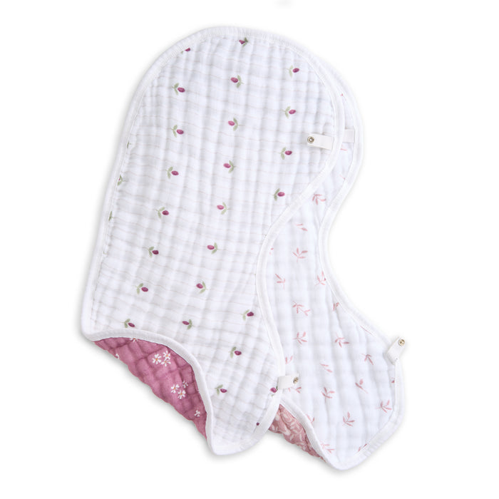 The aden + anais organic cotton muslin burpy bibs 2 pack includes GOTS certified, two-layered quilted bibs. One features a white background with pink and green flowers, while the reverse side has pink and white leaf designs. Both come with convenient snap closures.