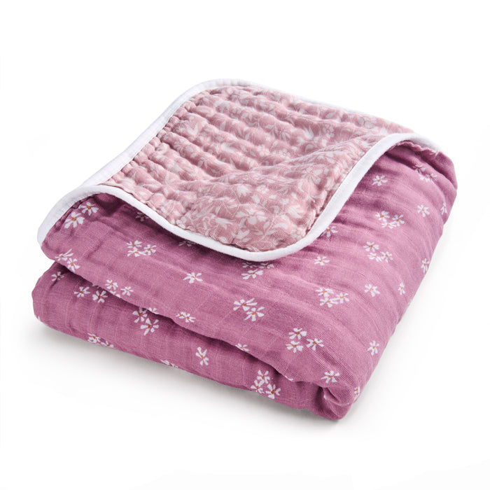 The aden + anais organic cotton muslin dream blanket, GOTS certified, is neatly folded to show its pink floral pattern with a white border and detailed inner floral design.