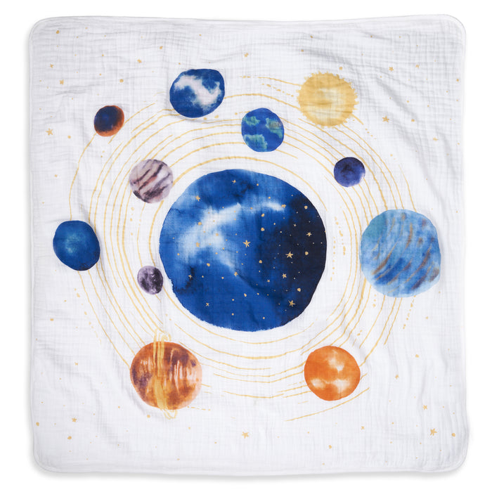 The aden + anais organic cotton muslin dream blanket features a vibrant solar system illustration with planets, swirling golden orbits, and stars on soft white fabric—perfect as crib bedding.
