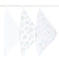 Three aden + anais organic cotton muslin oversized washcloths hang on a white rod, each boasting unique pastel patterns: one with small stars, another with hot air balloons, and the last with planets and clouds, all set against a simple white background.