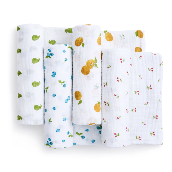 Four organic cotton muslin swaddle blankets by aden + anais showcase unique fruit patterns, including green pears, blue blueberries, yellow lemons, and pink cherries, all from the sustainable baby products line.