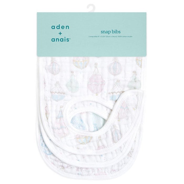 Pack of three aden + anais organic cotton snap bibs featuring a pastel hot air balloon design. These absorbent muslin bibs are crafted from soft, white organic cotton and are neatly folded with a light blue tag displaying the brand name and product details.