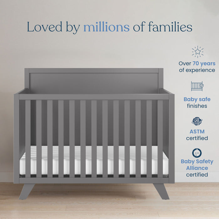 The Child Craft Soho 4-in-1 Flat Top Convertible Crib in Cool Gray is shown with a white mattress. With 70+ years of experience, baby-safe finishes, ASTM & Baby Safety Alliance certifications, it’s trusted by millions of families.
