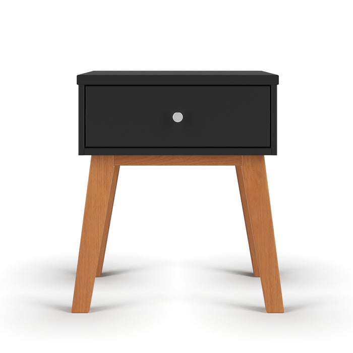 The Child Craft Soho Nightstand in Ebony features a sleek black drawer with a silver knob and four angled wooden legs, shown against a plain white background.