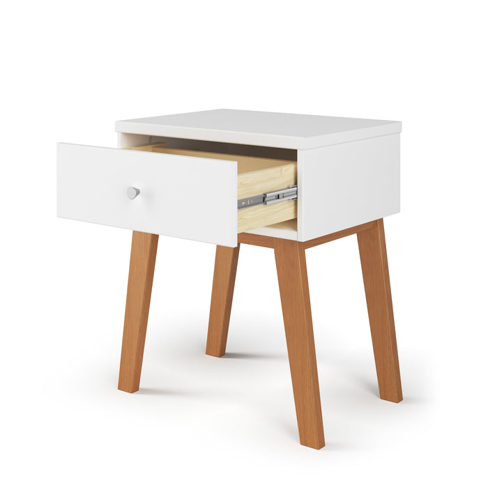 The Child Craft Soho Nightstand in White/Natural features a single open drawer with a light wood interior, a round silver knob, and four outward-angled wooden legs—ideal as nursery furniture or a kid's nightstand.