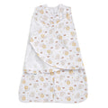 The HALO Swaddle 100% Cotton Muslin TOG 1.5 features a white adjustable design with playful yellow lions and brown monkeys, shown partially unfastened to reveal its cozy inner fabric and charming pattern—ideal for SleepSack Swaddle comfort.