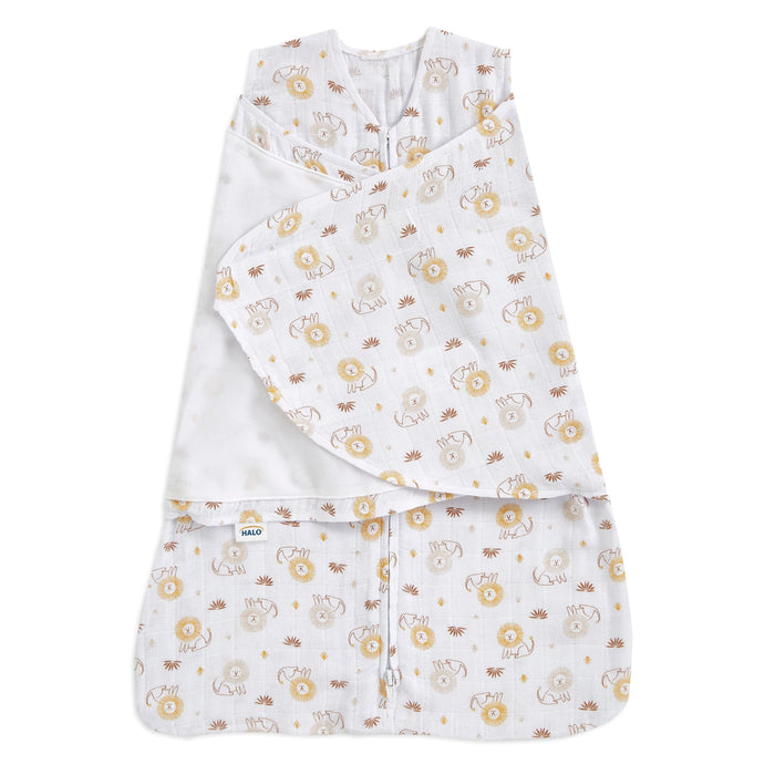 The HALO Swaddle 100% Cotton Muslin TOG 1.5 features a white adjustable design with playful yellow lions and brown monkeys, shown partially unfastened to reveal its cozy inner fabric and charming pattern—ideal for SleepSack Swaddle comfort.