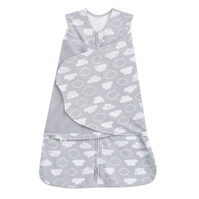 The HALO Swaddle 100% Cotton TOG 1.5 is a gray sleep sack with white clouds, featuring adjustable wings, a front zipper, wrap-around flap, and Velcro closures for easy swaddling while promoting healthy hip development.