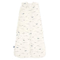 The HALO Swaddle 100% Cotton TOG 1.5 features a wrap-over design with adjustable wings and is adorned with a shark and fish pattern in soothing blue and gray. It boasts soft, cozy fabric and a convenient double zipper down the center.