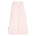 A pale pink HALO Swaddle 100% Cotton TOG 1.5 features a floral design with adjustable wings for healthy hip development and a wrap-around layout.
