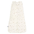 The HALO Swaddle 100% Cotton TOG 1.5 features a cream color with brown and green animal and tree prints. It has a sleeveless design, adjustable wings, and a Velcro-secured wrap-around flap to support healthy hip development for your little one.
