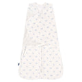 The HALO Swaddle 100% Cotton TOG 1.5 in white features light blue floral patterns on soft fabric, with adjustable wings for a snug fit and promotes healthy hip development. The widened bottom ensures comfort, and theres a small tag on the left edge.