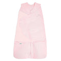 The HALO Swaddle 100% Organic Cotton TOG 1.5 is a light pink, sleeveless swaddle with crossover panels, a bottom zipper, and HALO branding—offering adjustable comfort and convenience for your baby.