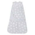The HALO Swaddle Micro-Fleece TOG 3.0, a gray wearable baby blanket with white stars, features adjustable wings and a front zipper. Its sleeveless design ensures healthy hip development while providing a soft, snug fit to keep your baby warm and secure.