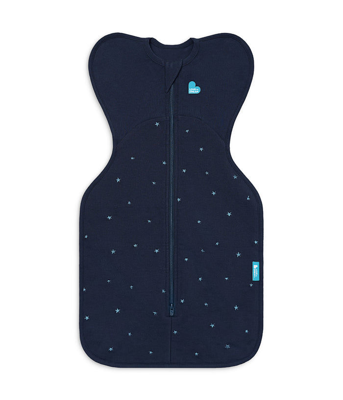 A baby sleep sack in dark navy blue with a small light blue star pattern, featuring a full-length front zipper and a small light blue heart logo on the chest.