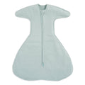 The HALO SwaddleStretch™ Newborn Swaddle TOG 0.5 features a center zipper, wide sleeves, and a roomy bottom. Made from soft fabric, this hip-healthy sleep sack ensures cozy comfort and warmth for infants.