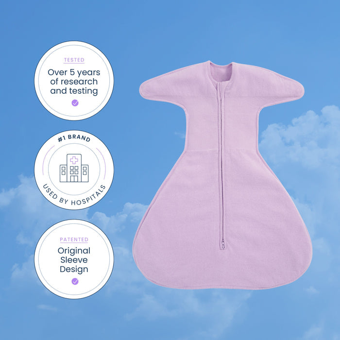 A HALO SwaddleStretch™ Newborn Swaddle TOG 0.5 in lavender, featuring a front zipper, is displayed against a blue sky background. Three badges highlight over five years of research, hospital usage, and its patented original sleeve design for this hip-healthy sleep sack.