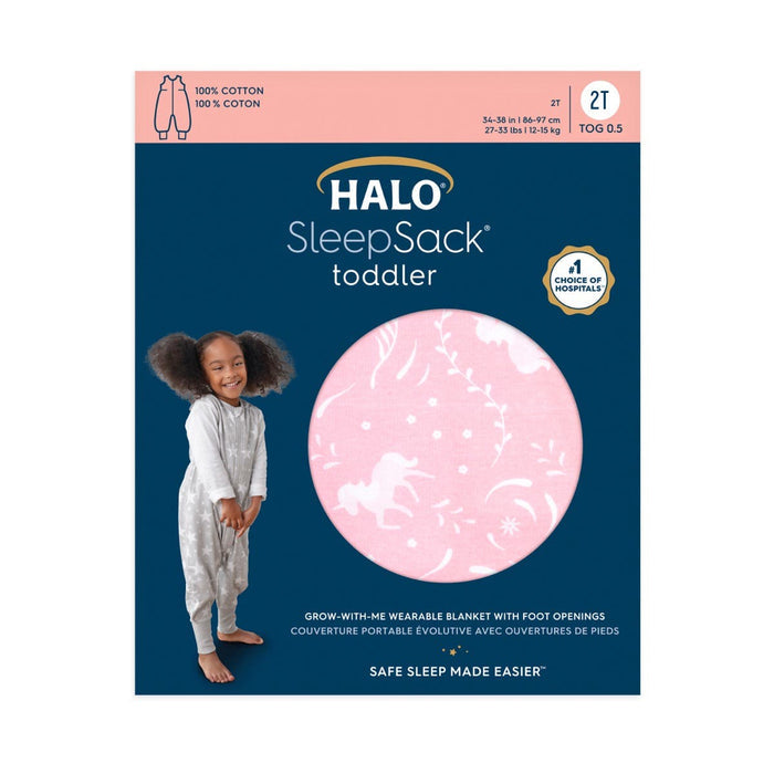 The HALO SleepSack Toddler 100% Cotton TOG 0.5 features a cozy design for better sleep. The blue packaging shows a girl in the pink SleepSack, decorated with unicorn and star patterns, ensuring all-night comfort.