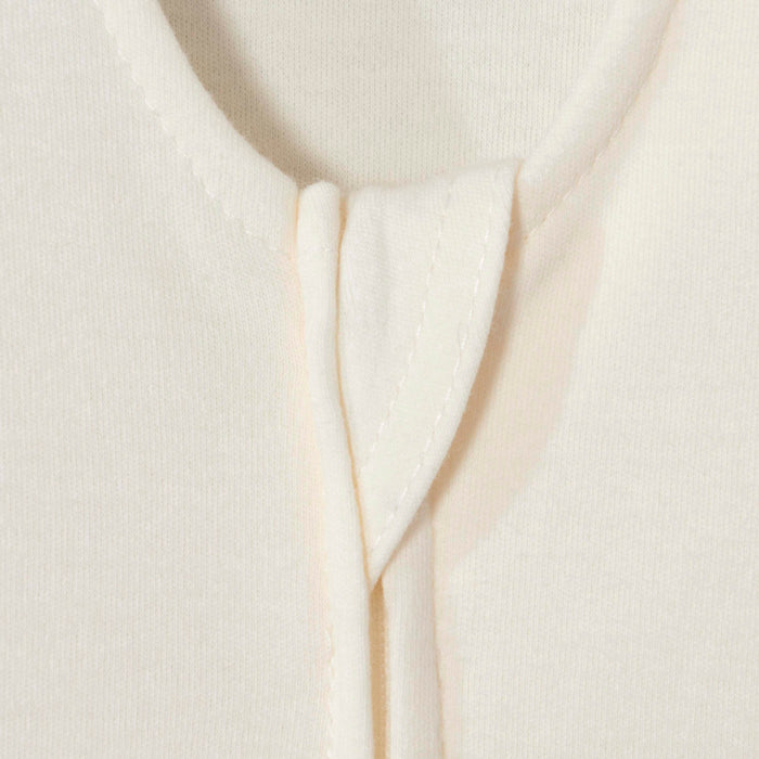Close-up of the cream-colored HALO Wearable Blanket 100% Cotton TOG 0.5 highlights its detailed neckline seam and stitching. The fabric is smooth and soft with neatly finished edges, ensuring safe sleep.