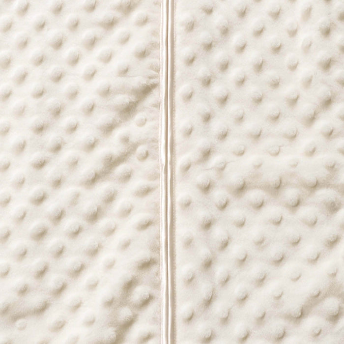 Close-up of HALOs Wearable Blanket Plushy Dot Velboa TOG 1.5, featuring soft, off-white textured fabric with raised dots. A vertical seam divides two identical sections for hip health and comfort during safe sleep.