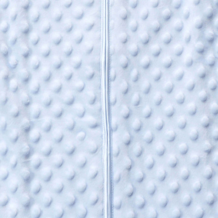 Close-up of HALOs Wearable Blanket Plushy Dot Velboa TOG 1.5 fabric in light blue, featuring evenly distributed circular bumps and a vertical seam for a cozy symmetrical look reminiscent of comfortable blanket wear.